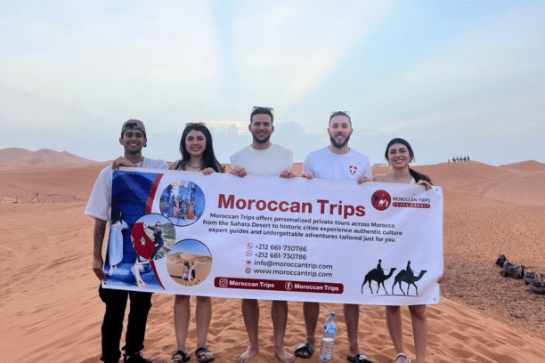 Happy travelers in the Merzouga Sahara Desert during a private Morocco desert tour with Moroccan Trips.